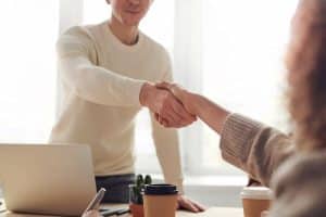 Two people shaking hands on a business deal.